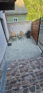 a patio with two chairs and a fire pit at Casa MIHNEA in Dălghiu