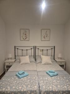a bedroom with a bed with two blue towels on it at Buhardilla barranquilla in Poyales del Hoyo