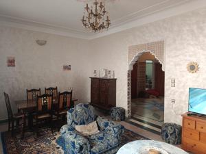 a living room with a table and chairs and a chandelier at Dar Cadi in Safi