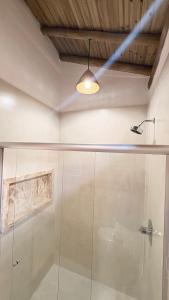 a bathroom with a shower with a glass door at Tupinambá Pousada e Hostel in Caraíva +45 photos