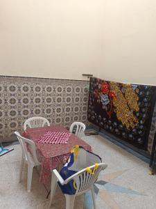 a room with a table and chairs and a wall at Dar Cadi in Safi