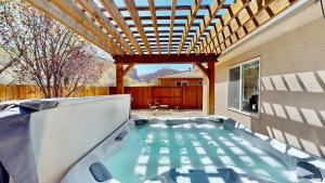 a hot tub in a backyard with a pergola at Canyon Portal #469 in Moab