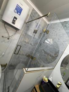 a glass shower in a room with a counter at Moto Guest House in Kochkorka