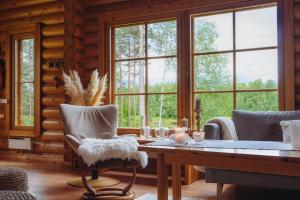 a living room with a table and chairs and windows at Northern Nest by Elys Collection in Kittilä
