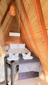 a bed in a wooden cabin with a ceiling at Tupinambá Pousada e Hostel in Caraíva
