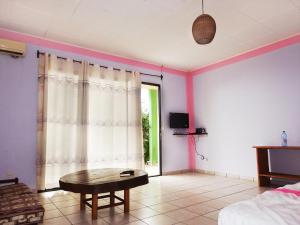 a living room with a table in a room with purple walls at BEAUSÉJOUR Plage in Kribi