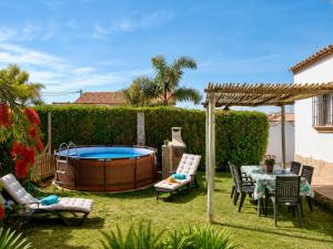 a backyard with a hot tub and a table and chairs at Chalet Duna in El Palmar