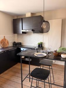 a kitchen with a table and chairs in a room at Au pied du mur in Huy