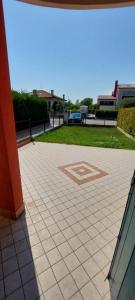 a tiled walkway with a building in the background at Mansuè, appartamento con giardino fra Oderzo e Pordenone in Mansuè