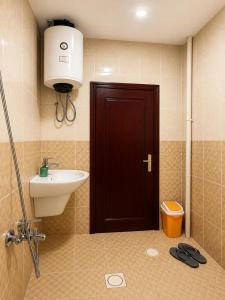 a bathroom with a sink and a toilet and a door at Liva Residency in Salalah