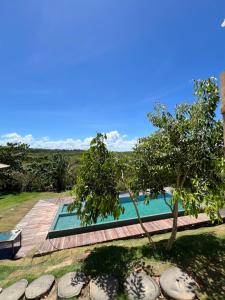 a swimming pool in a yard with a tree at Tupinambá Pousada e Hostel in Caraíva