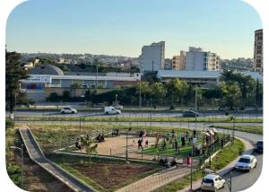 a group of people walking around a park in a city at Appartement Birkhadem in Birkhadem