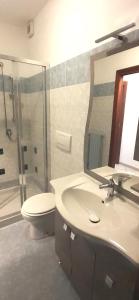 a bathroom with a sink and a toilet and a mirror at Via Roma OttantaDue in Valmadrera