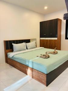 a bedroom with a large bed with a wooden headboard at Hillside Haven-Luxury Room in Nathon Bay