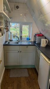 a small kitchen with a sink and a window at 1 Bedroom Cabin with Mountain & Loch Views - Quiet Location between Glencoe & Ben Nevis in Corran