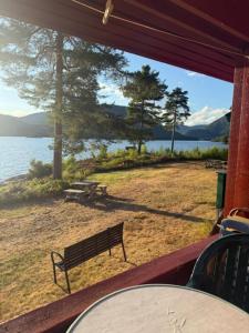 a bench on a porch with a view of the water at Longerak Camping in Bygland