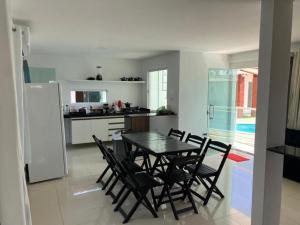 a kitchen and dining room with a table and chairs at Vila Bangalô in São José da Coroa Grande