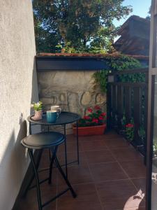 ein kleiner Tisch und zwei Hocker auf einer Terrasse in der Unterkunft Guest house Skabrin in Bansko