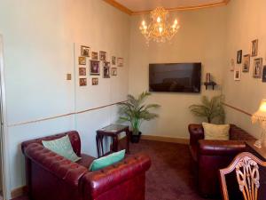 a living room with two leather couches and a television at Downton I in Alnwick