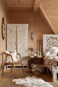 a bedroom with a bed and a table and a chair at Bajkowa LUX Magiczne Domki z Jacuzzi in Murzasichle
