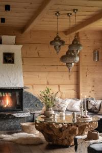 a living room with a table and a fireplace at Bajkowa LUX Magiczne Domki z Jacuzzi in Murzasichle