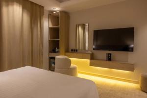 a hotel room with a bed and a flat screen tv at The Business Hotel By Seafront فندق ذا بيزنس in Jeddah