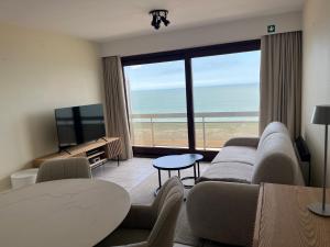 a living room with a view of the ocean at Studio Zeester in Westende-Bad