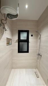 ein Badezimmer mit Dusche und Fenster in der Unterkunft هاوس تو 21 in Abha + 19 Fotos