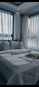 a bedroom with a large white bed with windows at Sky Beach Resort Ltd in Kisumu