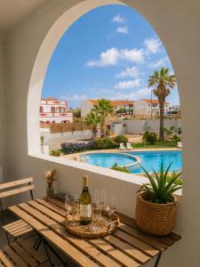a table with wine glasses and a view of a swimming pool at ENJOY POOL, BEACH and more at this nice 2bedroom apartment only 3 minutes from Mareta's Beach in Sagres