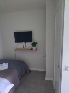 a bedroom with a bed and a television on a shelf at Hotel Sommarvind in Inkoo