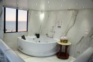 a white bathroom with a tub and a window at Inkari Apart Hotel in Lima +39 photos