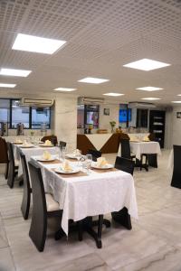 a dining room with tables and chairs with white table cloth at Inkari Apart Hotel in Lima