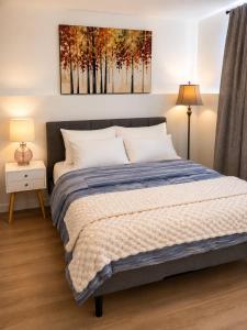 a bedroom with a bed and a painting on the wall at Modern Riverview Suite Near Downtown Moncton in Riverview