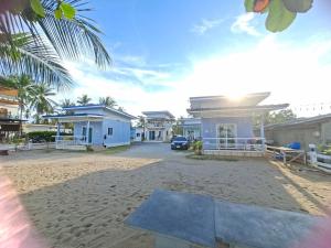 a house on the beach with a car parked in front at Chomlay House in Ban Thepha