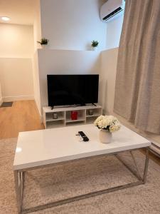 a white coffee table in a living room with a tv at Modern Riverview Suite Near Downtown Moncton in Riverview