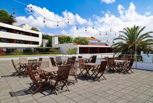 a group of tables and chairs on a patio at Antillia Hotel in Ponta Delgada