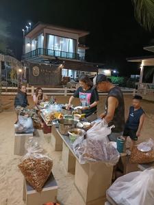 a group of people preparing food at a buffet at Chomlay House in Ban Thepha