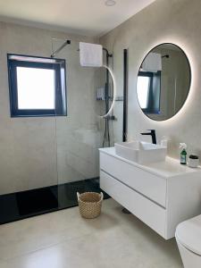 a bathroom with a white sink and a mirror at Casa Miralago - Gerês in Admeus +15 photos