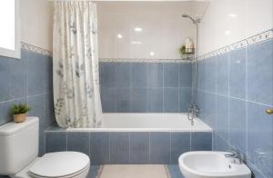 a bathroom with a toilet and a tub and a sink at El Rincón Sevillano in Gerena +23 photos