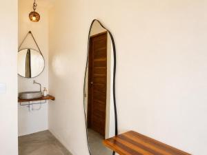 a hallway with a mirror and a wooden bench at The Wave Kite House in Guriú