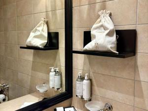 ein Badezimmer mit Spiegel und einer weißen Handtasche in der Unterkunft Hotel Rotary Geneva - MGallery in Genf + 97 Fotos