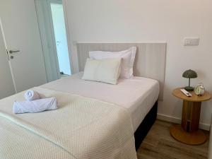 a bedroom with two beds with white sheets and a table at Casa Miralago - Gerês in Admeus