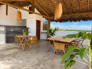 an outdoor patio with a wooden table and chairs at The Wave Kite House in Guriú