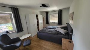 a small bedroom with a bed and a chair at FeWo Panoramablick Geislingen in Geislingen an der Steige