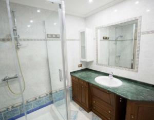 a bathroom with a sink and a glass shower at La Casona De Cuellar in Cuéllar