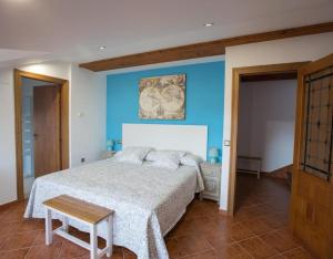 a bedroom with a bed with a blue wall at La Casona De Cuellar in Cuéllar