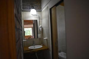 a bathroom with a sink and a mirror at Camping El Paraíso in El Hoyo +28 photos