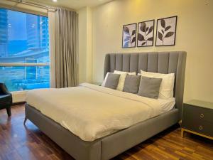 a bedroom with a large bed with a large window at SkyPark Premium Hotel Serviced Apartments - LMY Hospitality Gulberg Islamabad in Islamabad