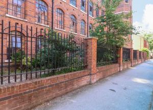 a brick building with a fence next to a street at Kick back relax stylish space in Nottingham